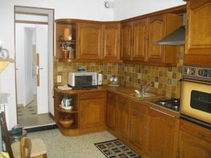 a kitchen with wooden cabinets and a microwave at maison entière in Fécamp