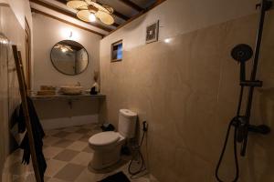 a bathroom with a toilet and a mirror at The Swan Villa in Gili Trawangan +12 photos