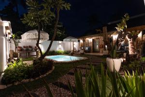 a backyard with a swimming pool at night at The Swan Villa in Gili Trawangan