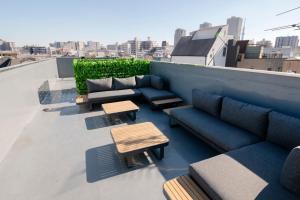 a patio with couches and tables on a roof at Edo stay senju in Tokyo