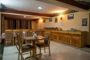 a restaurant with a table and chairs and a counter at Hotel Heritage in Kaza