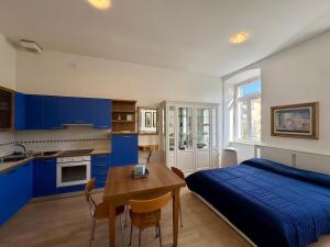a bedroom with a bed and a table and a kitchen at Villa Ercole in Grado