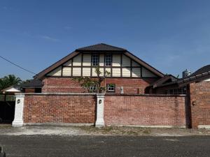 a red brick building with a tree in front of it at Dynz Cottage in Banting