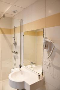 a white bathroom with a sink and a shower at Hotel Moderne in Arras +17 photos
