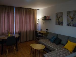 a living room with a couch and a table at Shazam Apartment Central, Stylish & Cozy near AUBG in Blagoevgrad