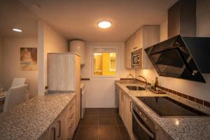 a kitchen with a sink and a counter top at Nova MSuites Catedrales in Foz