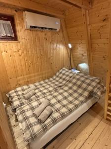 a bed in a wooden cabin with pillows on it at AA Apartman - Tópart in Kaposvár