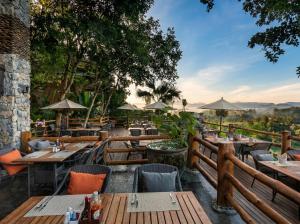 a restaurant with wooden tables and chairs and a fence at Katiliya Mountain Resort And Spa in Mae Salong Nai