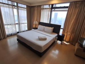 a bedroom with a large bed and large windows at Sunshine Suites Times square KL in Kuala Lumpur +50 photos