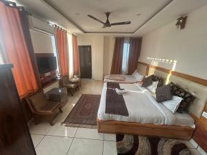 a bedroom with a large bed and a tv at Dadhwal B&B in Dharmsāla