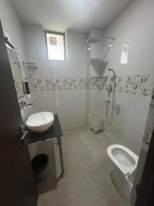 a bathroom with a toilet and a sink and a shower at Dadhwal B&B in Dharmsāla +49 photos