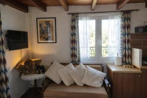 a living room with a couch with pillows and a window at Villa Dorothy - Mountain View Retreat, Polydrosos in Delphi