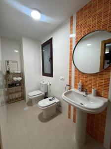 a bathroom with a sink and a toilet and a mirror at Casa Xandra in Tabernas +11 photos