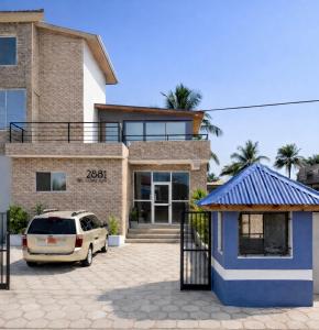 a house with a car parked in front of it at Tris Estates Hotel & Suites in Dwarzohn