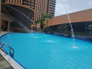 a large swimming pool with a water fountain at Sunshine Suites Times square KL in Kuala Lumpur