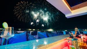 a table in a restaurant with a fireworks display in the background at Solaro Hotel & Spa Phu Quoc - Sunset Town Seaview & Fireworks in Phú Quốc +142 photos