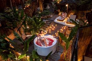 a woman sitting in a bath tub in a garden at Hatchu Khaoyai in Ban Bung Toei