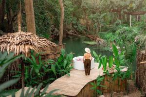 a person standing in a bath tub on a wooden bridge at Hatchu Khaoyai in Ban Bung Toei