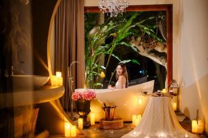 a woman in a bathtub in front of a mirror at Hatchu Khaoyai in Ban Bung Toei
