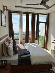 a bedroom with a large bed with a large window at Dadhwal B&B in Dharmsāla
