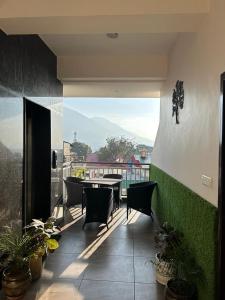 a patio with a table and chairs on a balcony at Dadhwal B&B in Dharmsāla