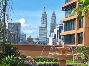 a fountain in front of a city with tall buildings at Sunshine Suites Times square KL in Kuala Lumpur