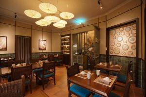 a restaurant with wooden tables and chairs and lights at Solaria Hanoi Hotel in Hanoi +54 photos