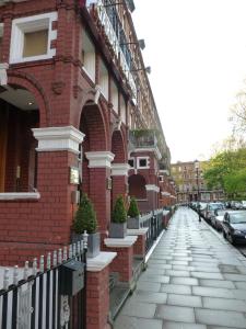 a brick building with a fence next to a street at Garden View Hotel in London
