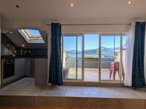 a kitchen with a large window with a view at Duplex sur la mer in LʼÎle-Rousse