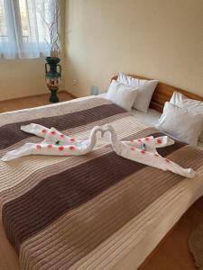 two towels are forming a heart on a bed at Zenora Apartman in Makó
