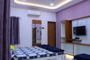 a bedroom with a bed and a tv in it at Laxman AC Lodge Jejuri - by Martandbhairav hospitality LLP in Jejūri