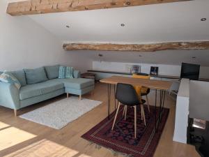 a living room with a couch and a table at Duplex sur la mer in LʼÎle-Rousse