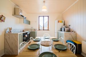 a kitchen with a table with green plates on it at Le Cocon Alsacien Parking privé Espace repas BBQ in Ebersheim