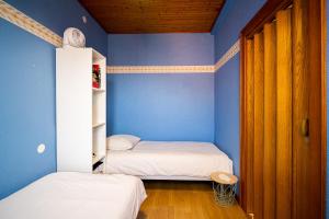 a room with two beds and a blue wall at Le Cocon Alsacien Parking privé Espace repas BBQ in Ebersheim