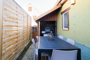 a table and chairs on a patio with a fence at Le Cocon Alsacien Parking privé Espace repas BBQ in Ebersheim