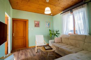 a living room with a couch and a table at Le Cocon Alsacien Parking privé Espace repas BBQ in Ebersheim
