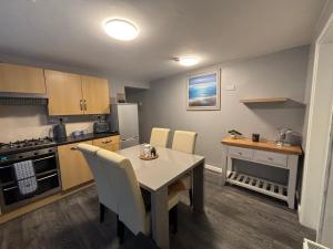 a kitchen with a table and chairs in a room at Neptune Nights in Pontnewynydd