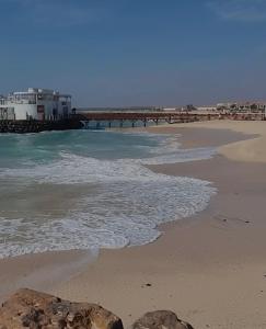 a view of the beach with a pier in the background at Ground floor Studio Vila Verde in Prainha
