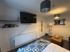 a bedroom with a bed and a flat screen tv at Neptune Nights in Pontnewynydd