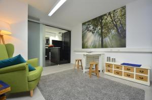 a living room with a green couch and a tv at Businessapart Stuttgart in Gäufelden