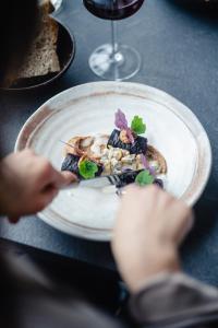 a person holding a plate of food on a table at Hôtel Château La Chèze - Bordeaux Floirac in Floirac