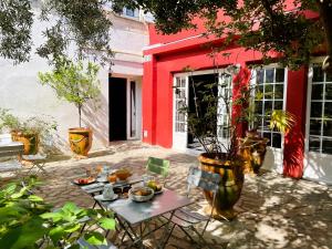 a table and chairs in front of a red building at Hotel Saint Louis - Au Coeur des Remparts in Aigues-Mortes