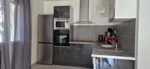 a kitchen with stainless steel appliances and a sink at Elsanais in Figari