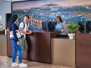 a group of people standing at a reception desk at Adagio Serris Val d'Europe in Serris