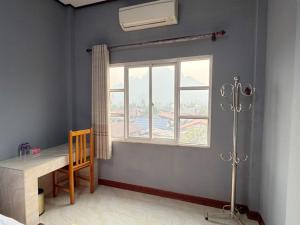 a room with a window and a table and a chair at Meesokxay Hotel Vang Vieng in Vang Vieng