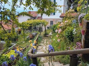 a garden with flowers and a fence at The Rooster House A Study in Green in Someraro