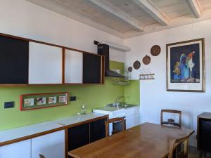 a kitchen with a wooden table and a sink at The Rooster House A Study in Green in Someraro