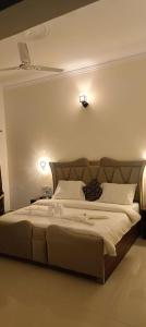 a large bed in a bedroom with two lights on the wall at Corbett Sun Shine in Rāmnagar +2 photos