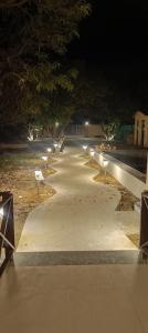a row of benches on a sidewalk at night at Corbett Sun Shine in Rāmnagar