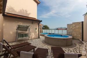 a patio with chairs and a swimming pool at Holiday Home Vele with pool in Vrgorac